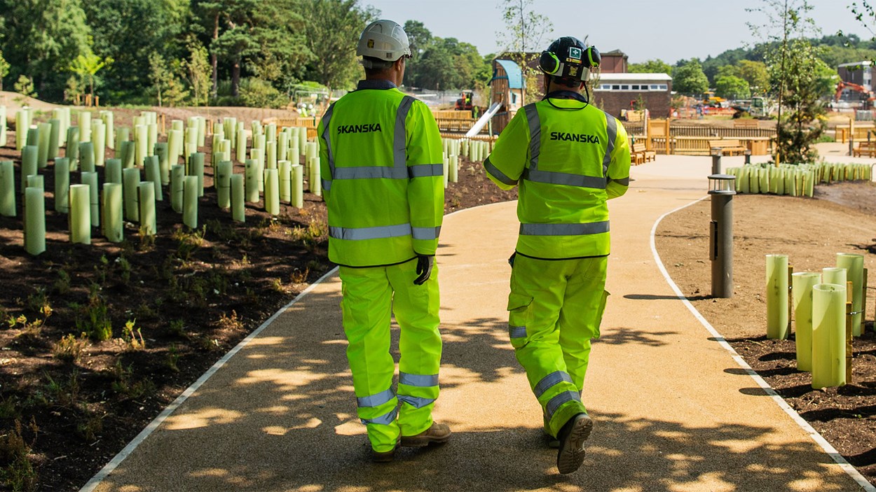 Two construction workers from Skanska, walking away, while on site at Worthy Down